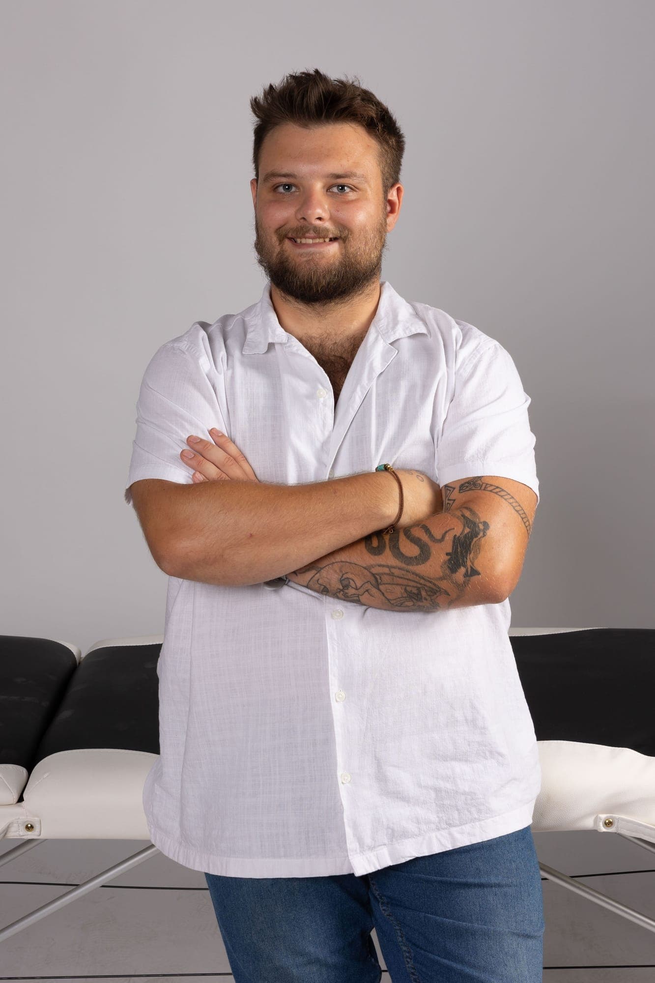 Uśmiechnięty portret masażysty przy stole do masażu